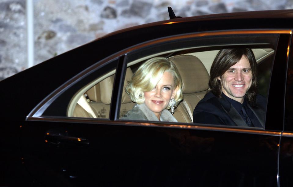 Then-couple Jenny McCarthy and Jim Carrey sitting in the back seat of a car arriving for the wedding.
