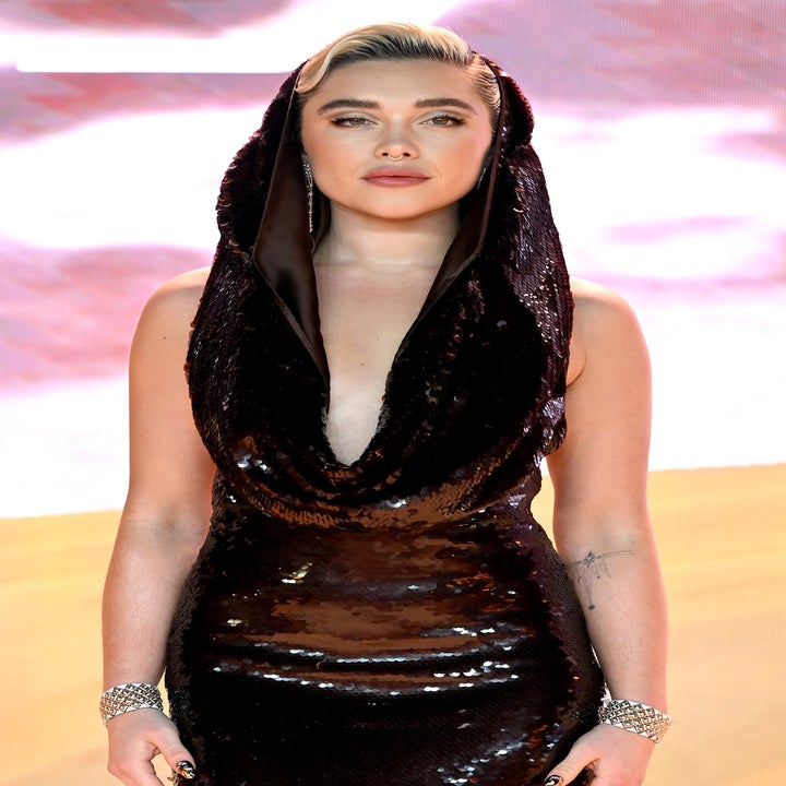 Florence Pugh in a deep V-neck sequined gown with a hood, posing on a carpet